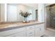 Bathroom featuring a double sink vanity, quartz countertops, and a walk-in shower with decorative tile at 832 Canonbury St, Henderson, NV 89011