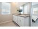 Bright bathroom featuring a double sink vanity with white cabinetry and a large mirror at 832 Canonbury St, Henderson, NV 89011