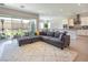 Open-concept living room with a large sectional sofa, a plush rug, and access to the backyard at 832 Canonbury St, Henderson, NV 89011