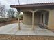 A covered backyard patio with double doors, desert landscaping, and tan pillars and ceiling at 9462 Alhambra Valley St, Las Vegas, NV 89178