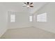 Bright bedroom featuring a ceiling fan, multiple windows, and neutral carpeting, offering a comfortable retreat at 9535 Stills Way, Las Vegas, NV 89148