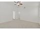 Large bedroom with a ceiling fan, neutral carpet, and a door to the ensuite bathroom creating a relaxing ambiance at 9535 Stills Way, Las Vegas, NV 89148