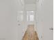 Clean hallway with doors and wood-look floors leading to a bright window at 9535 Stills Way, Las Vegas, NV 89148