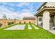 Picturesque backyard with artificial turf, a stone patio, and manicured greenery, creating a private outdoor oasis at 9876 Heather Moore Ave, Las Vegas, NV 89166