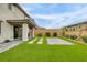 Expansive backyard featuring artificial turf, a covered patio, and lush landscaping, perfect for outdoor activities at 9876 Heather Moore Ave, Las Vegas, NV 89166