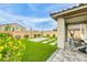 Charming backyard featuring manicured lawn, stone patio, and outdoor seating area, perfect for entertaining at 9876 Heather Moore Ave, Las Vegas, NV 89166