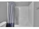 White tiled shower and tub combo with a light blue shower curtain with soft natural lighting at 9876 Heather Moore Ave, Las Vegas, NV 89166
