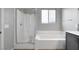 Bright bathroom featuring a combined shower and tub with a glass door, and a neutral color scheme at 9876 Heather Moore Ave, Las Vegas, NV 89166