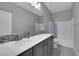 Well-lit bathroom with a dual-sink vanity, a white countertop, and modern fixtures, creating a clean and inviting space at 9876 Heather Moore Ave, Las Vegas, NV 89166