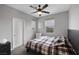 Neutral bedroom featuring a plaid comforter, ceiling fan, and bright natural light from the two windows at 9876 Heather Moore Ave, Las Vegas, NV 89166