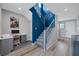 Inviting entryway with stylish staircase, blue accent wall, and convenient home office space at 9876 Heather Moore Ave, Las Vegas, NV 89166