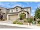 Inviting two-story home with a paved driveway, two-car garage, and beautifully landscaped front yard at 9876 Heather Moore Ave, Las Vegas, NV 89166