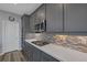 Chic kitchen featuring gray cabinetry, quartz countertops, and stainless steel appliances at 9876 Heather Moore Ave, Las Vegas, NV 89166
