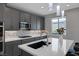 Contemporary kitchen boasting gray cabinets, quartz countertops, and stainless steel appliances at 9876 Heather Moore Ave, Las Vegas, NV 89166