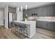 Modern kitchen featuring sleek gray cabinets, stainless steel appliances, and a center island with bar seating at 9876 Heather Moore Ave, Las Vegas, NV 89166