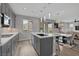 Spacious kitchen area with gray cabinetry and stainless steel appliances, seamlessly connecting to the living area at 9876 Heather Moore Ave, Las Vegas, NV 89166