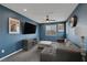 Inviting living room features a comfy sofa, a large TV for entertainment, and blue painted walls at 9876 Heather Moore Ave, Las Vegas, NV 89166