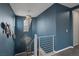 Stylish staircase with blue walls, modern railing, decorative lighting, and artistic wall decor at 9876 Heather Moore Ave, Las Vegas, NV 89166