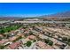 Wide aerial view of neighborhood featuring mature trees, landscaping, nearby golf course, and distant mountain backdrop at , North Las Vegas, NV 89084