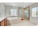 Bright bathroom featuring a soaking tub, tiled shower, and dual windows at , North Las Vegas, NV 89084