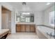 Bright bathroom with soaking tub, walk-in shower, vanity and a large mirror at , North Las Vegas, NV 89084