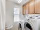 Laundry room featuring a window, wooden cabinets, and a white washer and dryer at , North Las Vegas, NV 89084