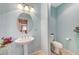 Light-blue powder room with pedestal sink, oval mirror, and convenient commode at , North Las Vegas, NV 89084