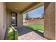 Covered patio featuring brick pavers, artificial turf, brick wall, and door to the house at 10116 Skye Castle Dr, Las Vegas, NV 89166
