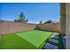 Backyard featuring artificial turf, stone walkway, privacy wall, and easy maintenance at 10116 Skye Castle Dr, Las Vegas, NV 89166