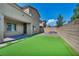 Wide view of the backyard featuring artificial turf, brick pavers, a fire pit, and brick walls at 10116 Skye Castle Dr, Las Vegas, NV 89166