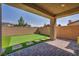 Backyard with artificial turf, brick pavers, brick wall, and covered patio, creating a low-maintenance outdoor space at 10116 Skye Castle Dr, Las Vegas, NV 89166