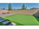 Backyard with artificial turf, fire pit, retaining wall, and block wall for privacy at 10116 Skye Castle Dr, Las Vegas, NV 89166