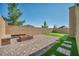 Backyard with brick pavers, artificial turf, a fire pit, and a built-in bench at 10116 Skye Castle Dr, Las Vegas, NV 89166