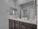 Bathroom featuring dual sinks, dark wood cabinets, and a large mirror at 10116 Skye Castle Dr, Las Vegas, NV 89166