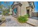 Side view of home boasts a neutral color palette and stone accents with an attractive brick paver walkway and lush landscaping at 10116 Skye Castle Dr, Las Vegas, NV 89166