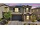 Two-story home boasts a neutral color palette, stone accents, and a two-car garage with an attractive brick paver driveway at 10116 Skye Castle Dr, Las Vegas, NV 89166