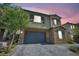 Two-story home boasts a neutral color palette, stone accents, and a two-car garage with an attractive brick paver driveway at 10116 Skye Castle Dr, Las Vegas, NV 89166