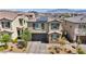 Two-story home with a two-car garage, paver driveway, and manicured landscaping with mountain views at 10116 Skye Castle Dr, Las Vegas, NV 89166