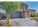 Two-story home boasts a neutral color palette, stone accents, and a two-car garage with an attractive brick paver driveway at 10116 Skye Castle Dr, Las Vegas, NV 89166