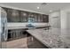 Updated kitchen boasts granite countertops, dark wood cabinetry and stainless steel appliances at 10116 Skye Castle Dr, Las Vegas, NV 89166