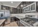 Modern kitchen with stainless steel appliances, dark cabinetry, and granite countertops at 10116 Skye Castle Dr, Las Vegas, NV 89166