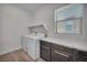 Bright laundry room featuring a washer and dryer set, storage cabinets, and wood-look flooring at 10116 Skye Castle Dr, Las Vegas, NV 89166
