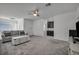 Spacious living room featuring plush gray carpeting and a ceiling fan at 10116 Skye Castle Dr, Las Vegas, NV 89166