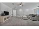 Bright living room with cozy sofa, plush carpeting, and large entertainment center at 10116 Skye Castle Dr, Las Vegas, NV 89166