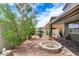Landscaped backyard featuring a covered patio area with desert features and a rock firepit at 1017 Pebble Lake St, Henderson, NV 89011