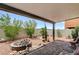 Covered patio area with desert landscaping, a rock water feature, and block wall at 1017 Pebble Lake St, Henderson, NV 89011