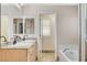 Bright bathroom features double sinks with granite counters, tub, and tile flooring at 1017 Pebble Lake St, Henderson, NV 89011