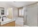 Bright bathroom features double sinks with granite counters, tub, and shower with decorative glass door at 1017 Pebble Lake St, Henderson, NV 89011