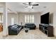 Bright living room featuring tile flooring, ceiling fan, and large windows with shutters at 1017 Pebble Lake St, Henderson, NV 89011