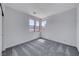 Bright bedroom featuring neutral gray walls, carpeting, and natural light from the triple window at 1038 Delbrook Ave, Henderson, NV 89012